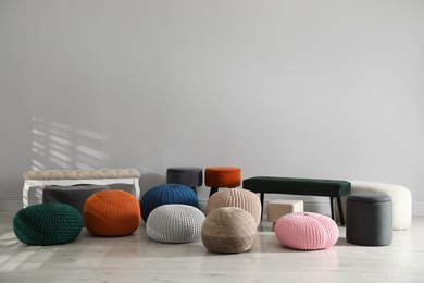 Many stylish different poufs and benches indoors. Home design