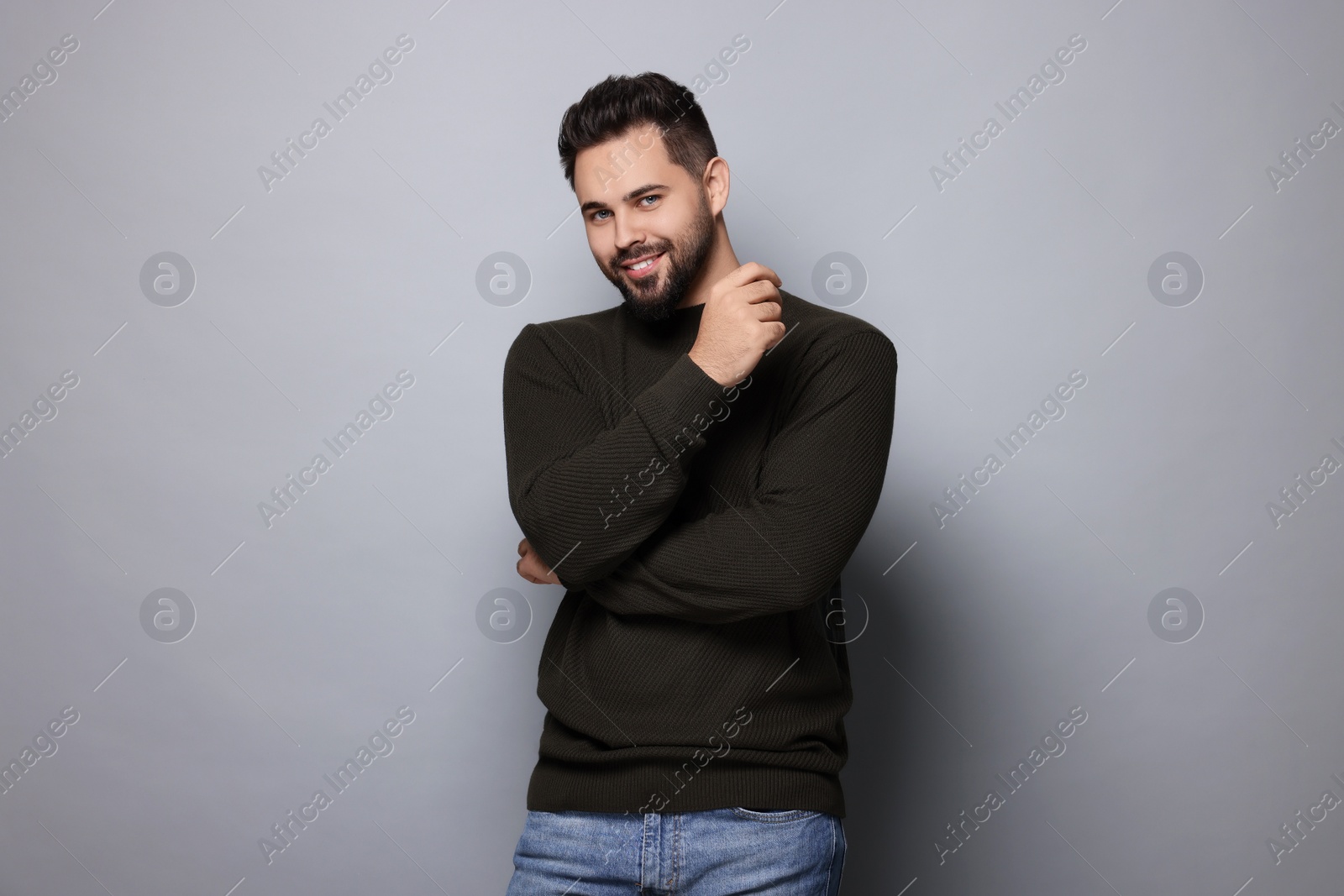 Photo of Happy man in stylish sweater on grey background