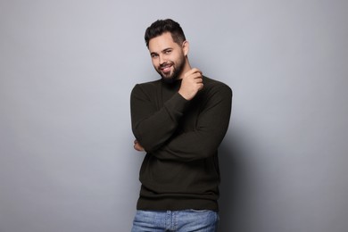 Photo of Happy man in stylish sweater on grey background
