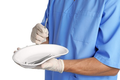 Male doctor holding dish with medical tools on white background, closeup. Medical objects