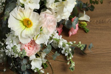 Photo of Bouquet of beautiful flowers on wooden table, closeup