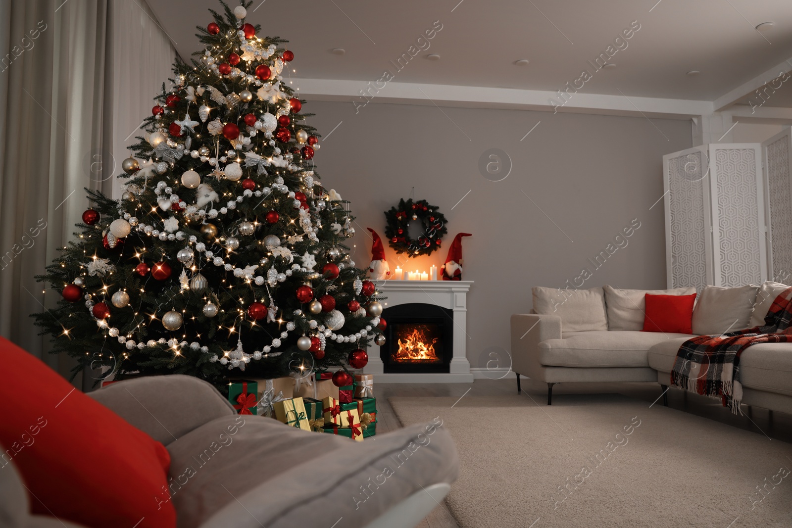 Photo of Beautiful Christmas tree and many gift boxes in stylish living room interior