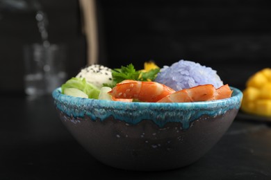 Photo of Delicious poke bowl served on black table, closeup