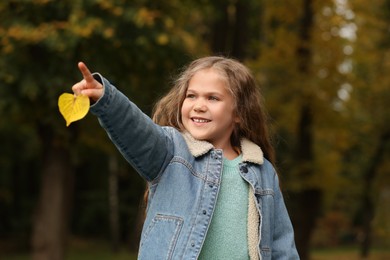 Photo of Portrait of happy girl with autumn dry leaf outdoors