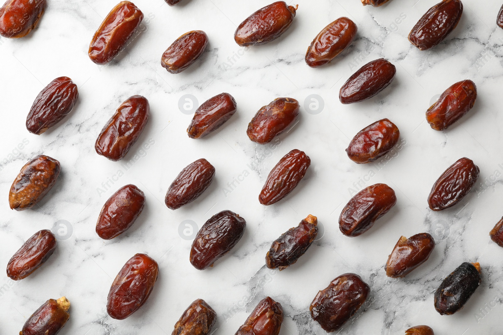 Photo of Flat lay composition with dates on marble background. Dried fruit as healthy snack