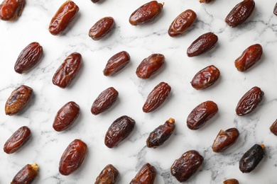 Photo of Flat lay composition with dates on marble background. Dried fruit as healthy snack