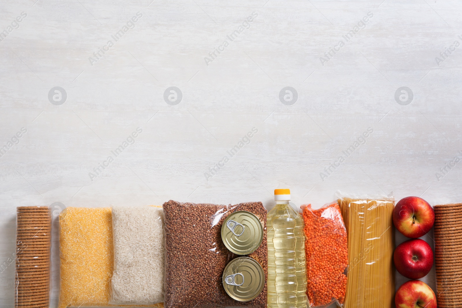 Photo of Many different products and space for text on white wooden background, flat lay. Food donation