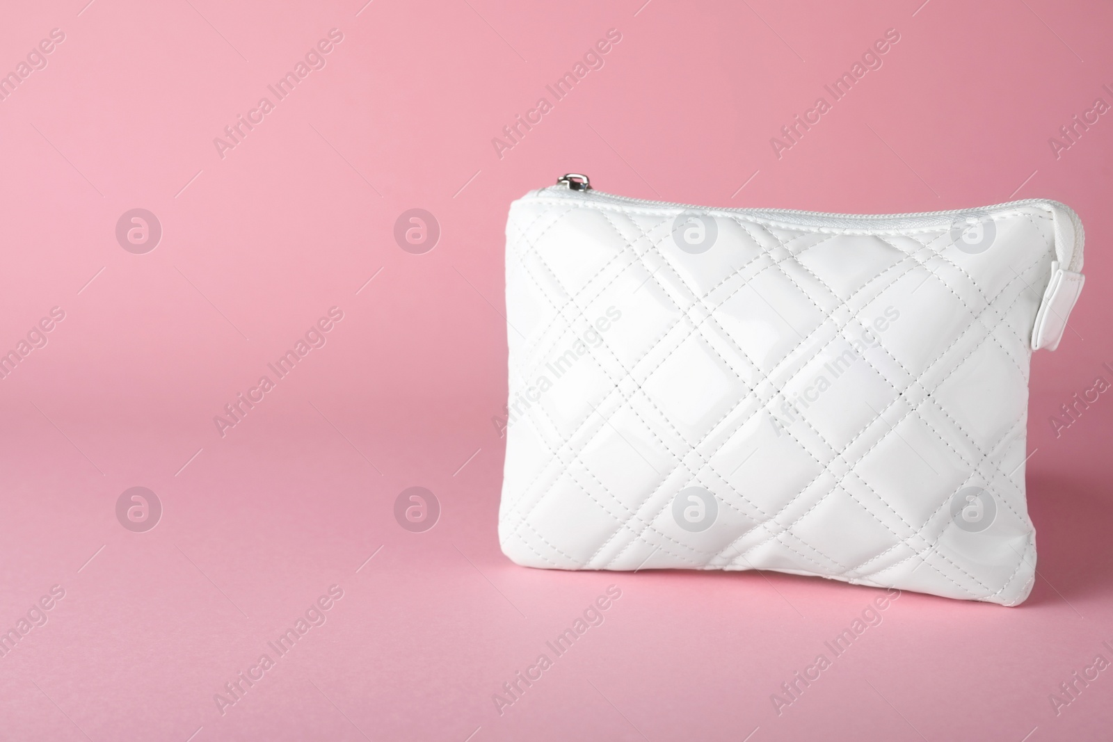 Photo of White leather cosmetic bag on pink background. Space for text