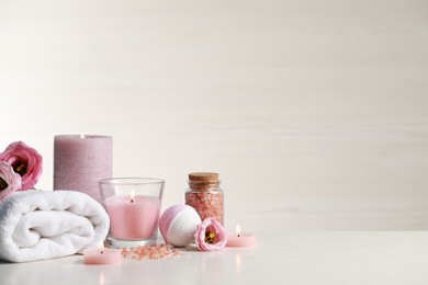 Beautiful composition with burning candles and different spa products on white table. Space for text