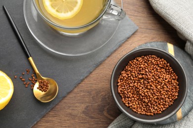 Photo of Buckwheat tea and granules on wooden table, flat lay