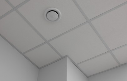 Photo of White ceiling with PVC tiles indoors, low angle view