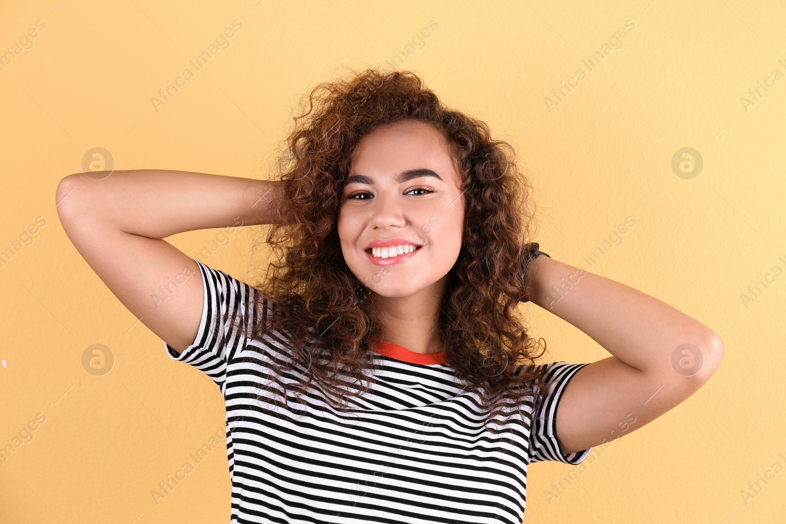 Photo of Portrait of young laughing African-American woman on color background