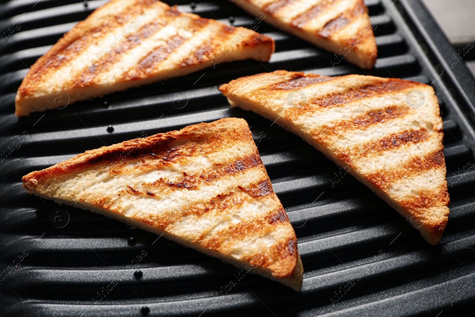 Photo of Modern sandwich maker with bread slices, closeup