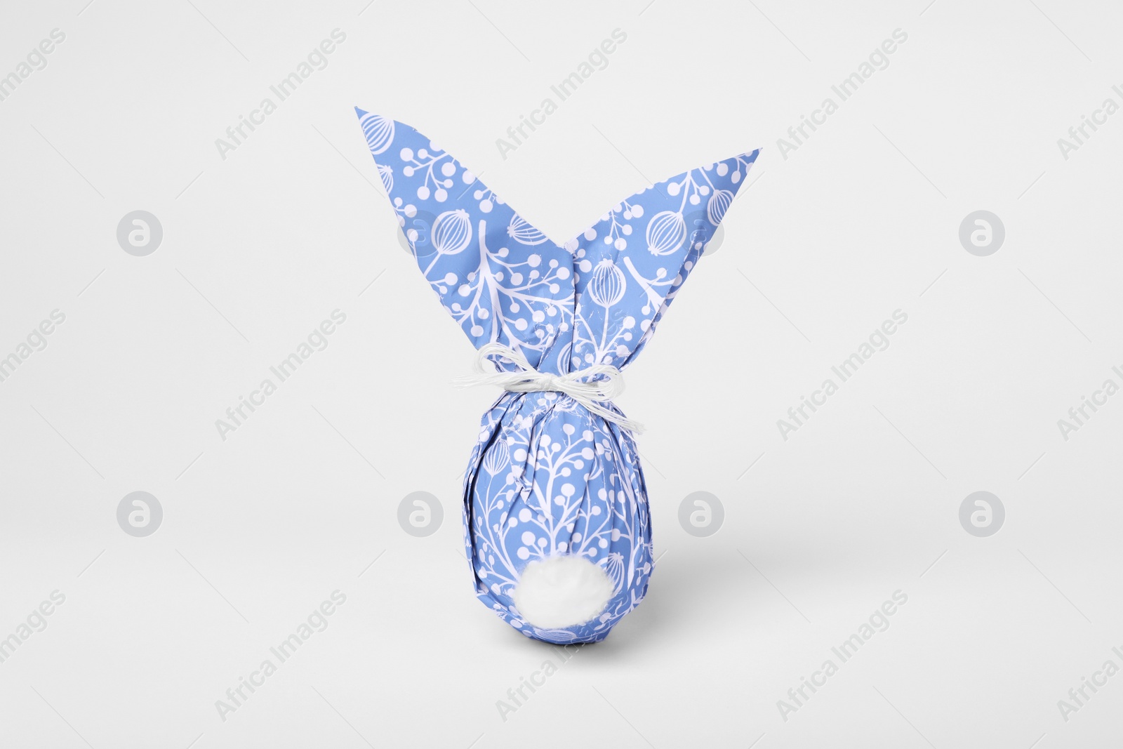 Photo of Easter bunny made of wrapping paper and egg on white background