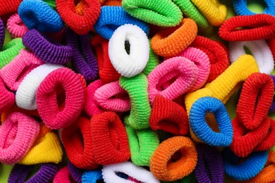 Photo of Different colorful hair ties as background, closeup