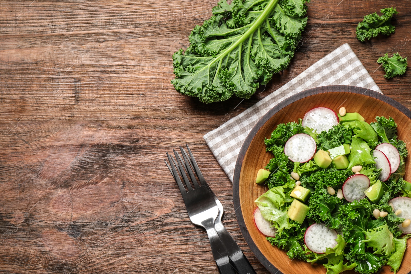 Photo of Delicious kale salad on wooden table, flat lay. Space for text