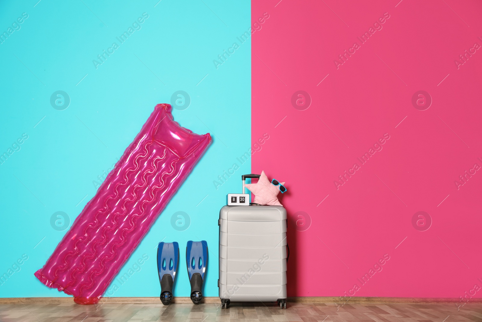 Photo of Large suitcase for travelling and beach items with space for text near color wall