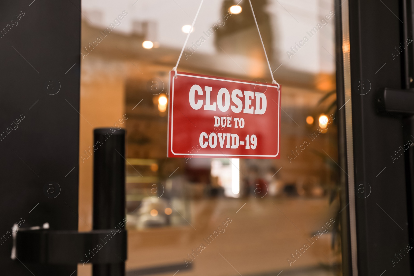 Photo of Red sign with words "Closed Due To Covid-19" hanging on glass door