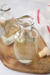 Vinegar in glass jug and bottle on table