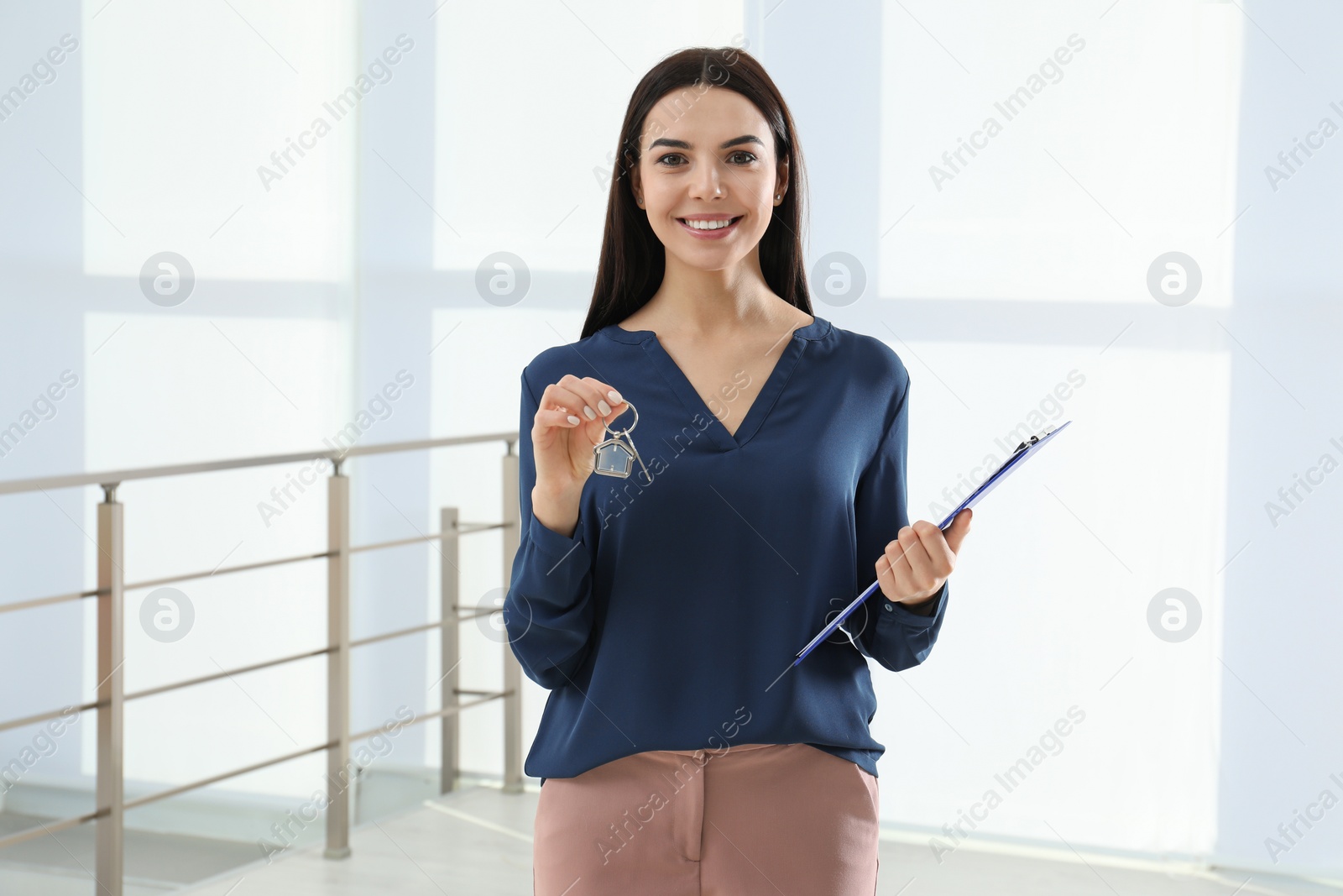 Photo of Female real estate agent holding key in new apartment