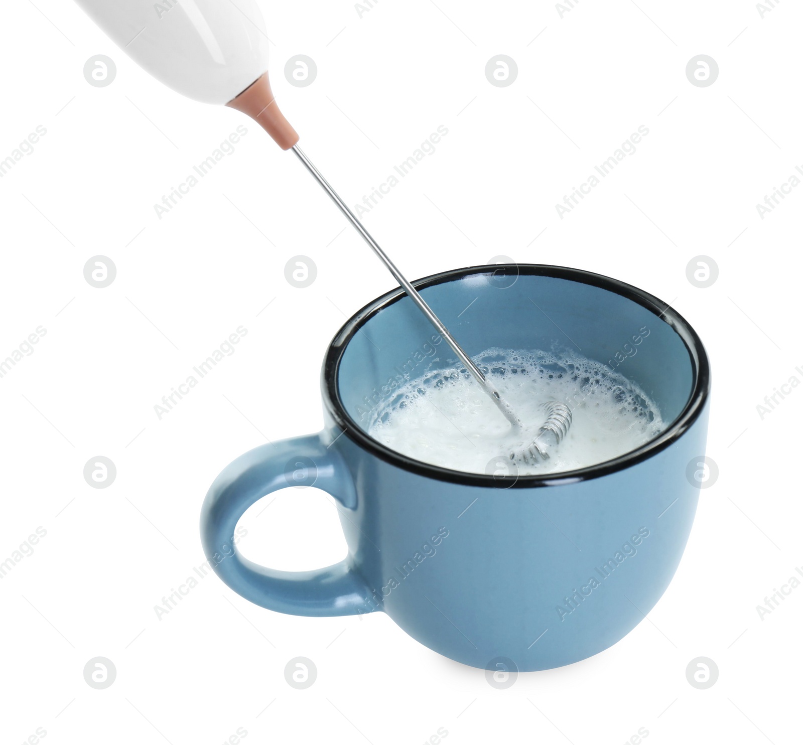 Photo of Whisking milk in cup with mini mixer (frother wand) isolated on white, closeup