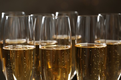 Glasses of champagne on dark background, closeup