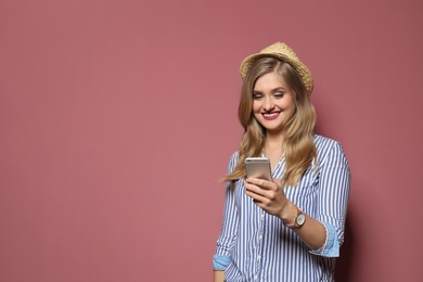 Photo of Attractive young woman with smartphone on color background