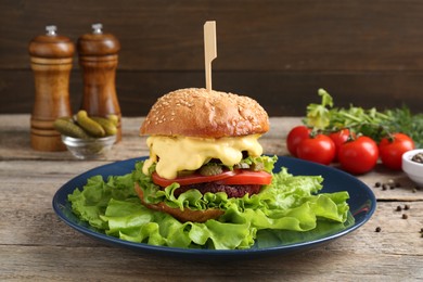 Photo of Delicious vegetarian burger and ingredients on wooden table