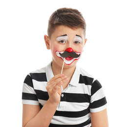 Preteen boy with clown makeup and fake mustache on white background. April fool's day