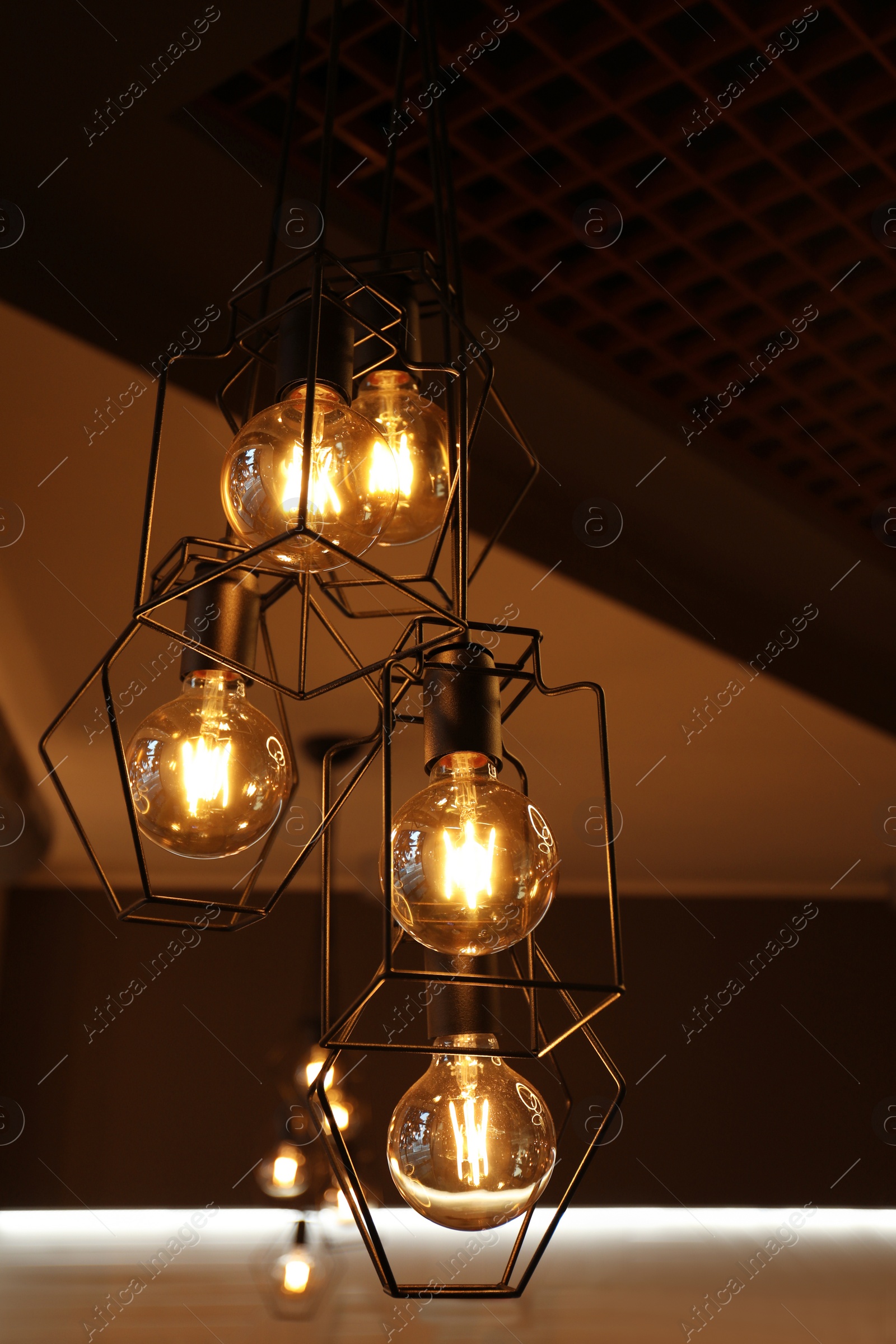 Photo of Pendant lamps with glowing light bulbs indoors