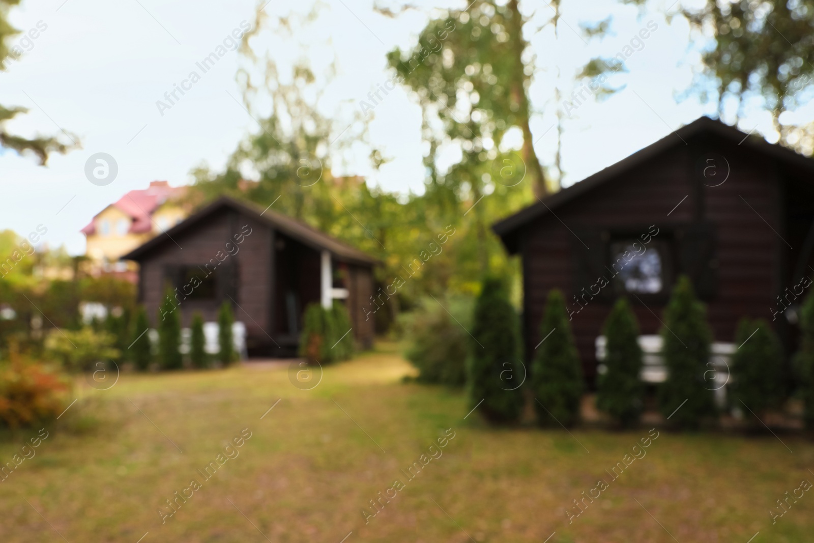 Photo of Blurred view of cozy wooden houses outdoors