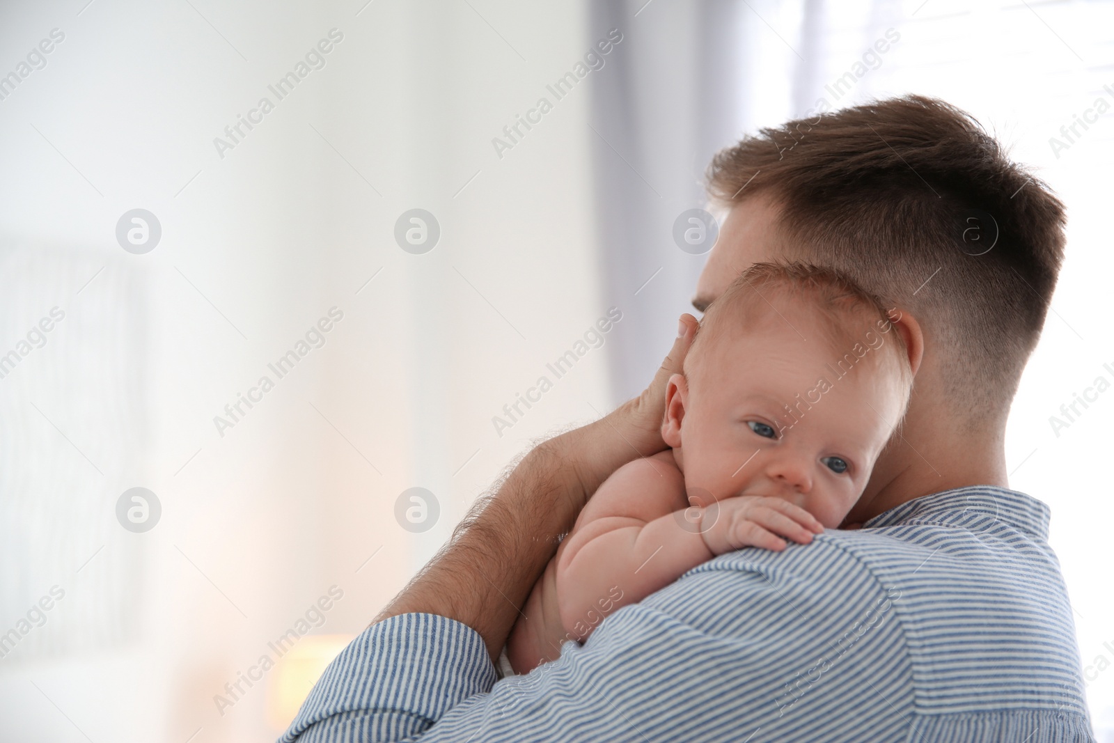 Photo of Father with his newborn son at home. Space for text