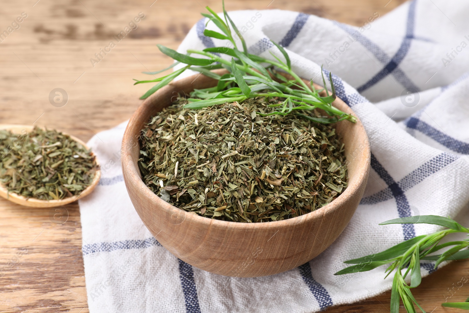 Photo of Dry and fresh tarragon in bowl on wooden table, closeup