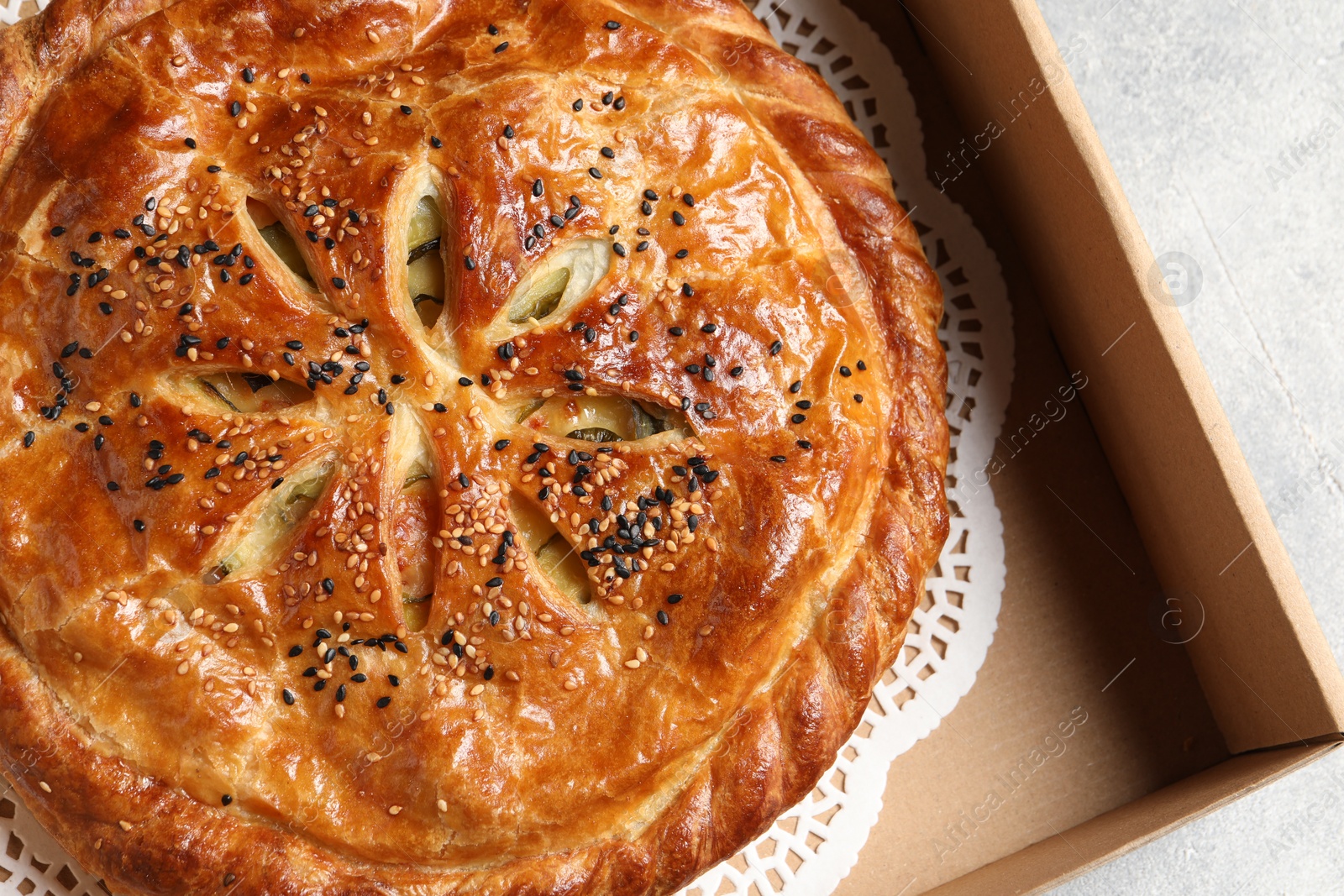 Photo of Tasty homemade pie in box on light table, top view