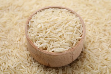 Bowl and raw rice as background, closeup