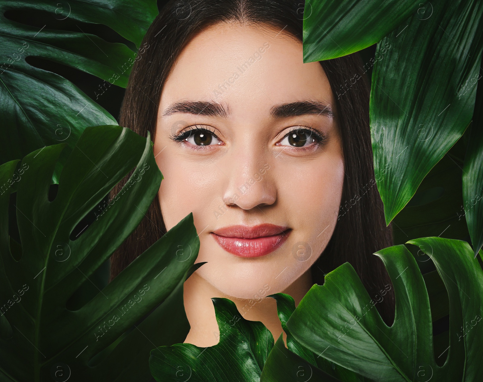 Image of Beautiful young woman feeling harmony while enjoying nature. Girl surrounded by green leaves