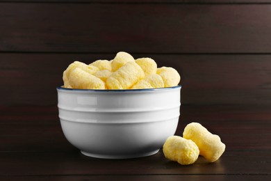 Photo of Bowl with corn sticks on dark wooden table