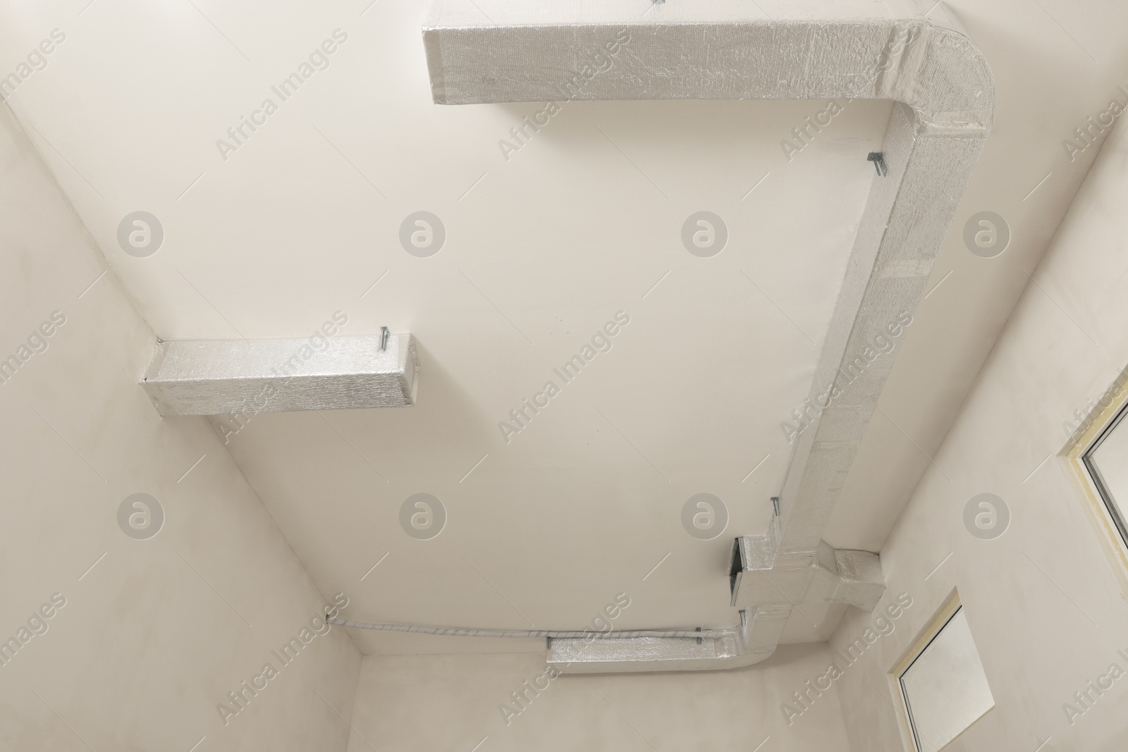 Photo of New ventilation system on beige ceiling indoors