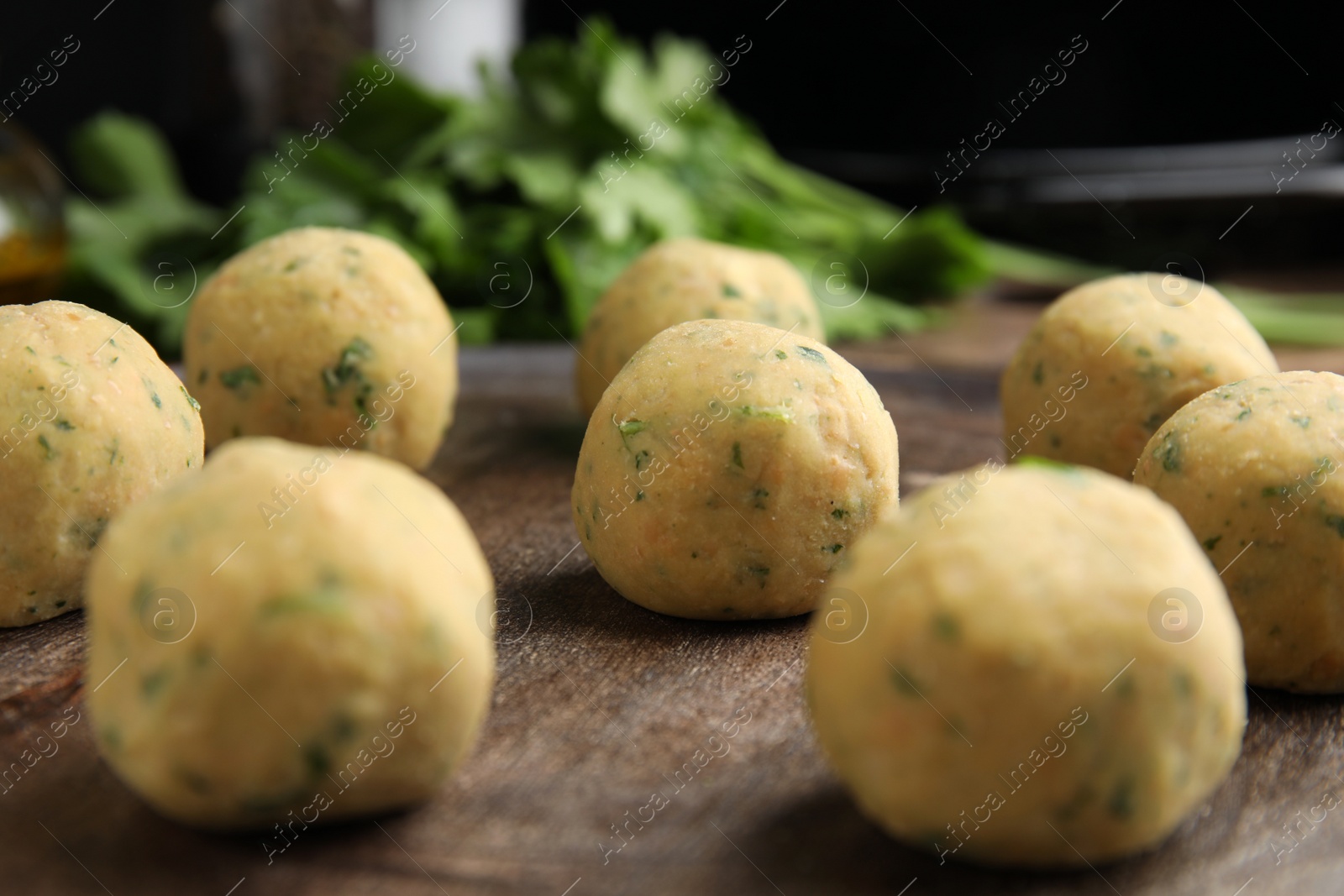 Photo of Raw falafel balls on wooden board, closeup