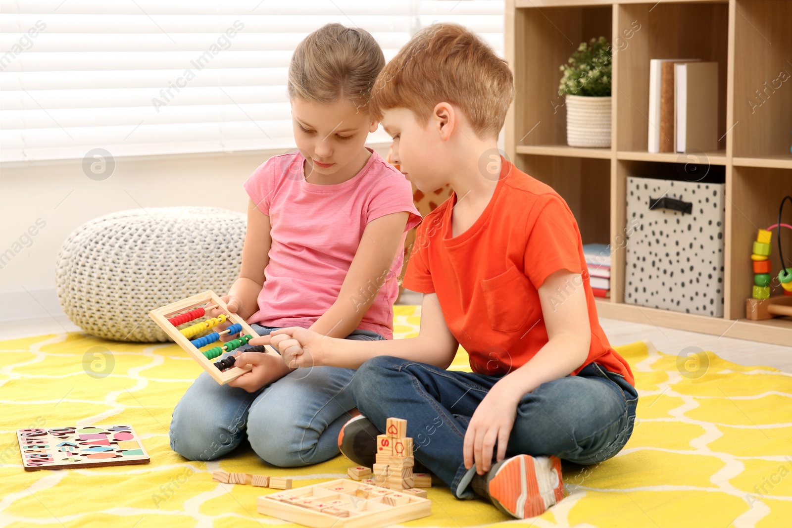 Photo of Children playing with abacus on floor in room. Learning mathematics with fun