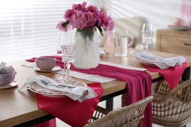 Photo of Beautiful table setting with pink peonies in dining room