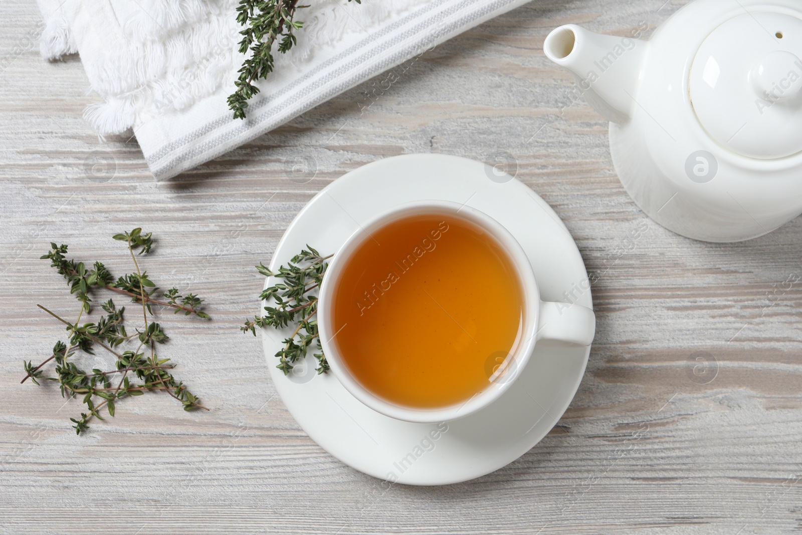 Photo of Aromatic herbal tea with thyme on white wooden table, flat lay