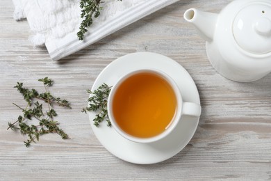 Photo of Aromatic herbal tea with thyme on white wooden table, flat lay