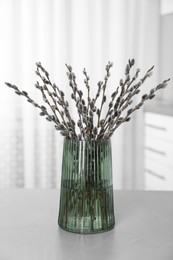 Photo of Beautiful bouquet of pussy willow branches on table indoors