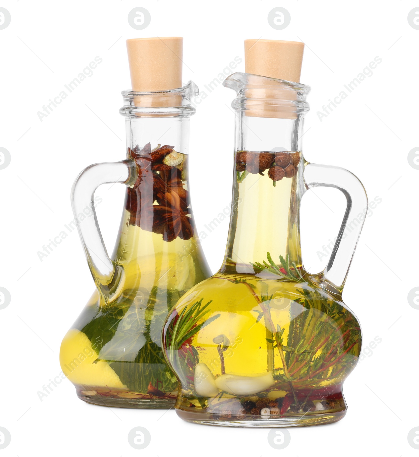 Photo of Glass jugs of cooking oils with spices and herbs on white background