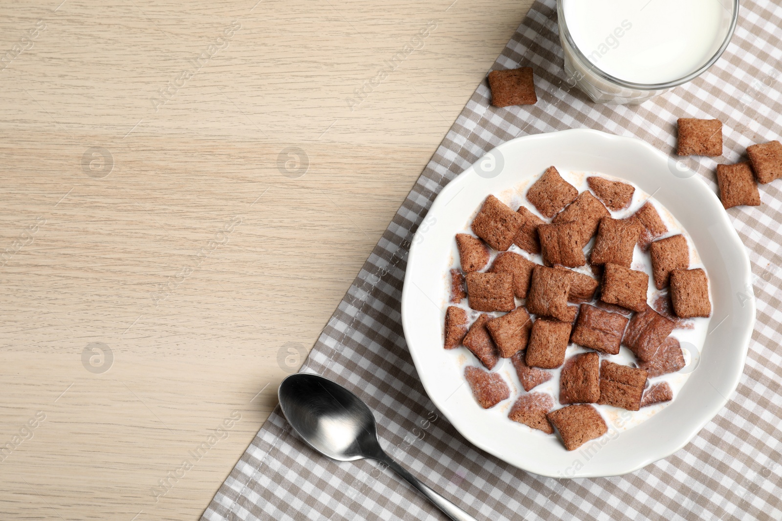 Photo of Bowl with tasty corn pads and milk on wooden table, flat lay. Space for text