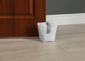 Photo of Stuffed bag holding wooden door at home