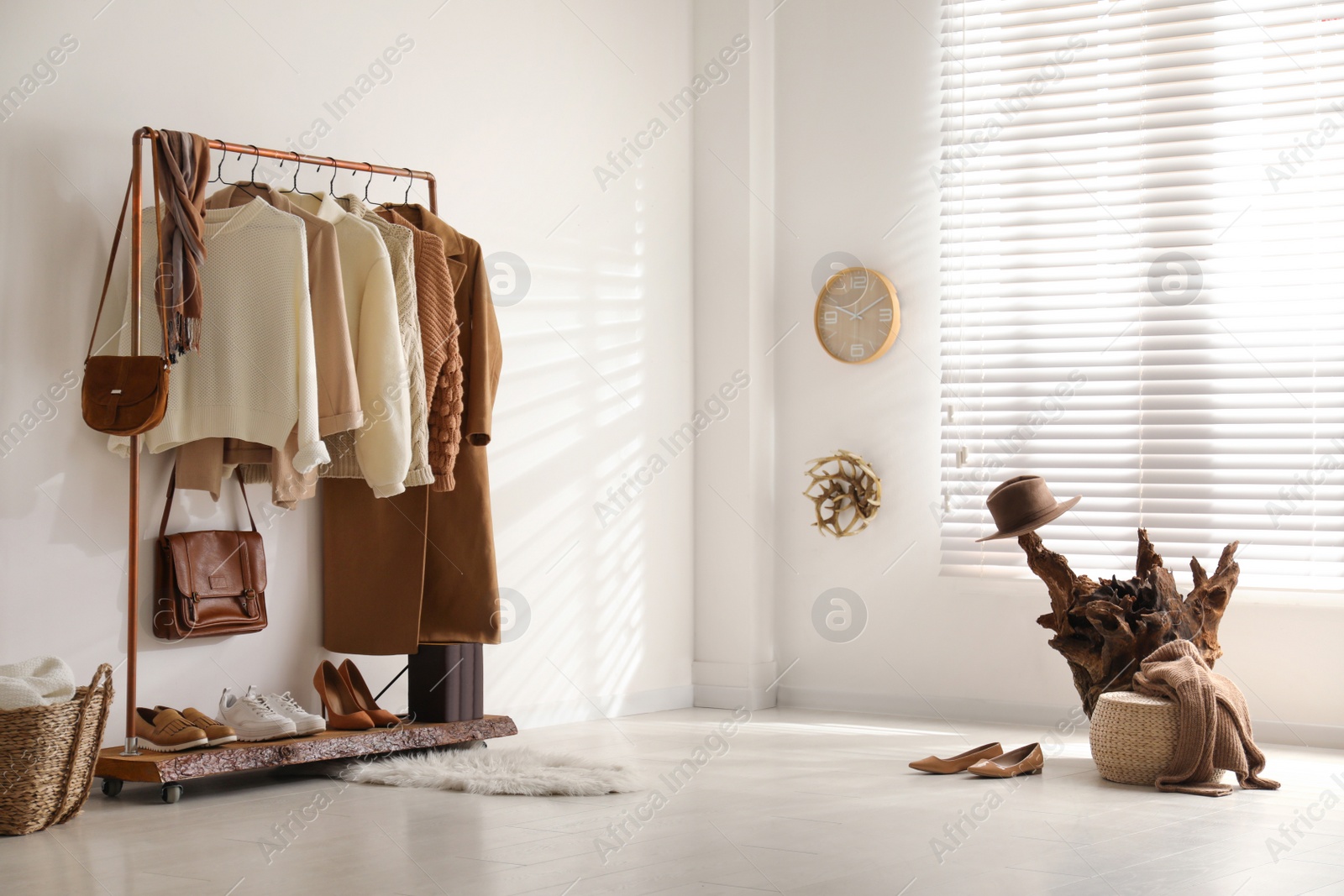 Photo of Modern dressing room interior with rack of stylish shoes and women's clothes