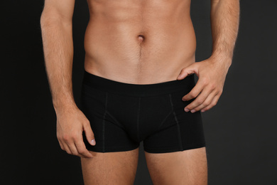 Man in underwear on black background, closeup