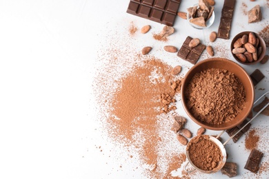 Photo of Flat lay composition with cocoa powder, beans and chocolate on light background
